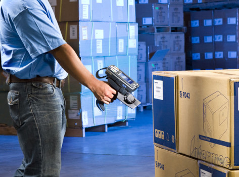 Warehouse worker scanning box with a mobile device.